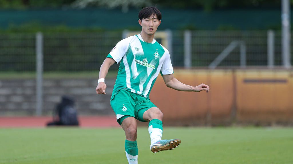 Min-woo Kim führt den Ball im Spiel gegen Holstein Kiel.