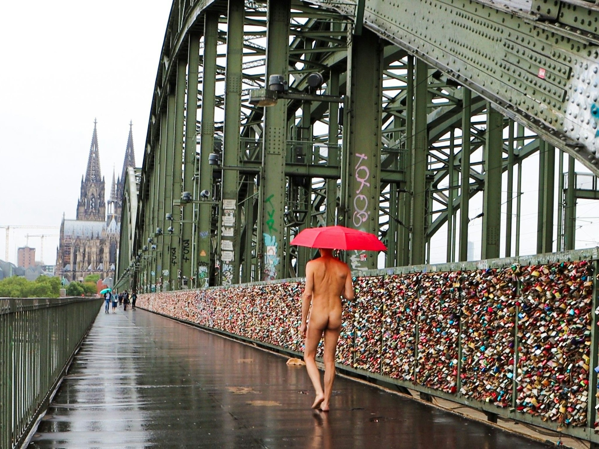 Ein nackter Mann läuft über die Hohenzollernbrücke.