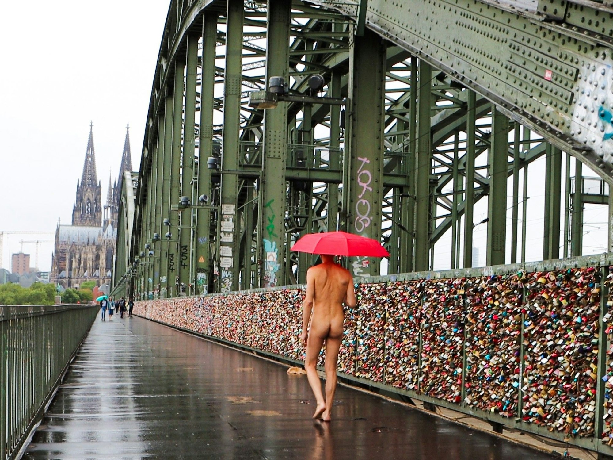 Ein nackter Mann läuft über die Hohenzollernbrücke.