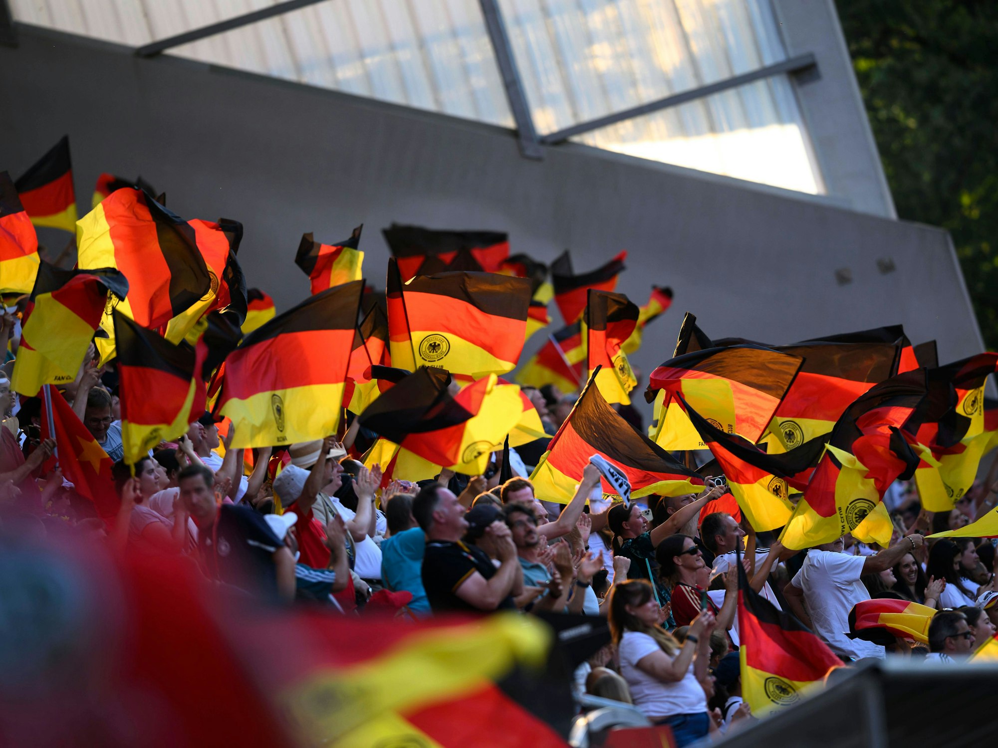 Deutschland-Fans schwingen Fahnen auf der Tribüne.