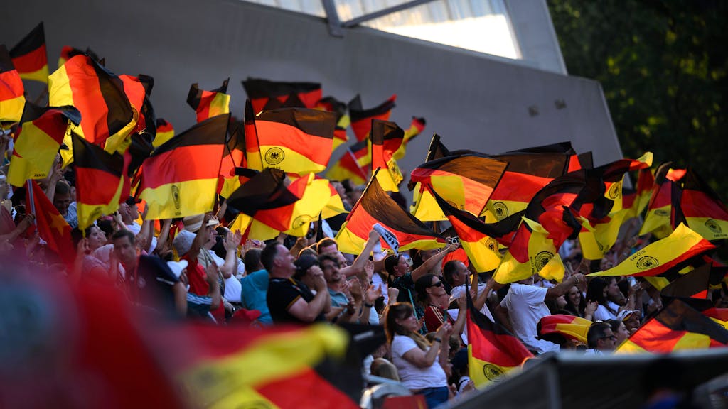 Deutschland-Fans schwingen Fahnen auf der Tribüne.