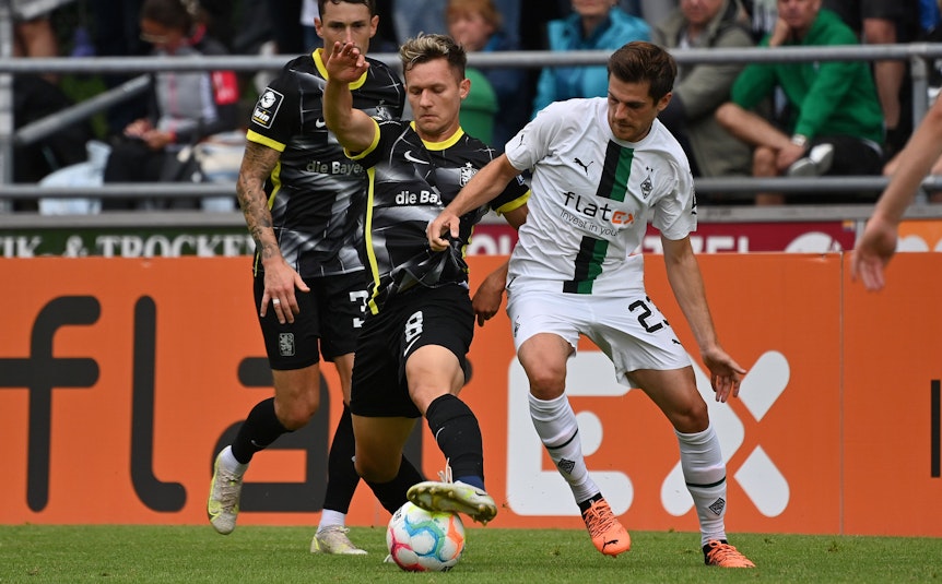 Jonas Hofmann von Borussia Mönchengladbach im Zweikampf mit Erik Tallig und Niklas Lang vom TSV 1860 München.