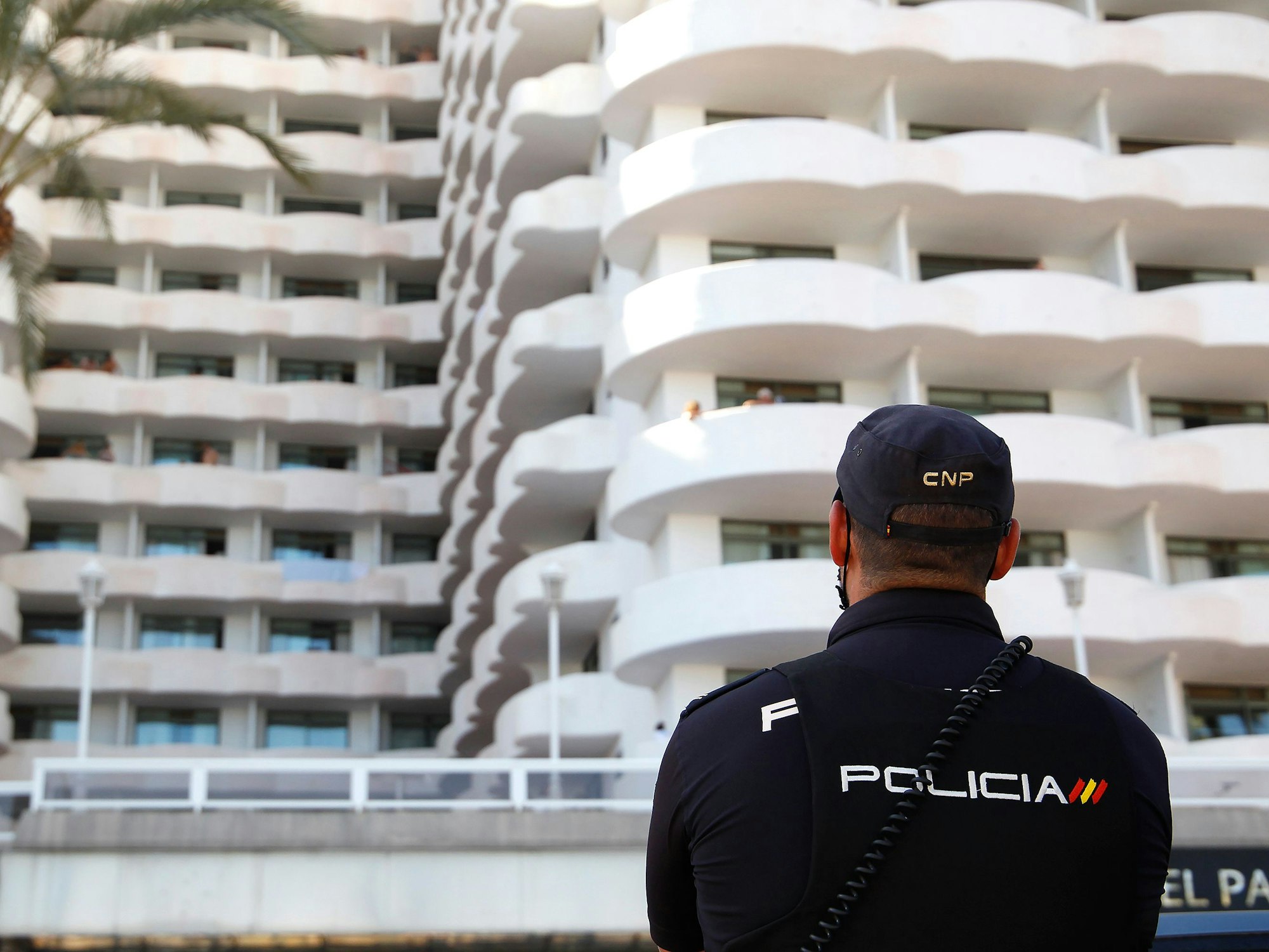 Ein Polizist steht vor einem Hotel.