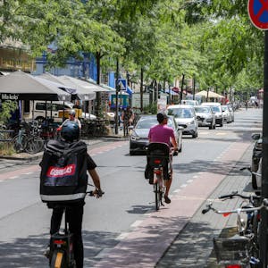 Fahrradfahrer fahren über die Venloer Straße in Köln-Ehrenfeld.