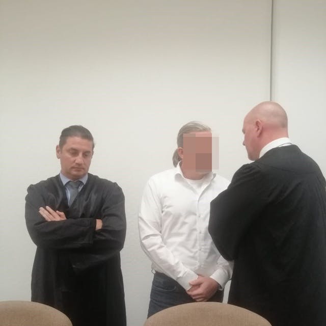 Das Bild zeigt den Hürther mit seinen beiden Anwälten.
