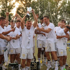 Die Spieler des SC Germania Erftstadt-Lechenich jubeln nach dem Sieg im Endspiel und recken den Pokal in die Höhe.