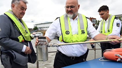&nbsp;Axel Scholl (M), Hauptkommissar, zeigt auf dem Wasserschutzboot WSP 1 auf dem Rhein Herbert Reul (CDU,l) eine Wasserprobe die er mit Valentino West (r), Kommissaranwärter, genommen hat.&nbsp;&nbsp;