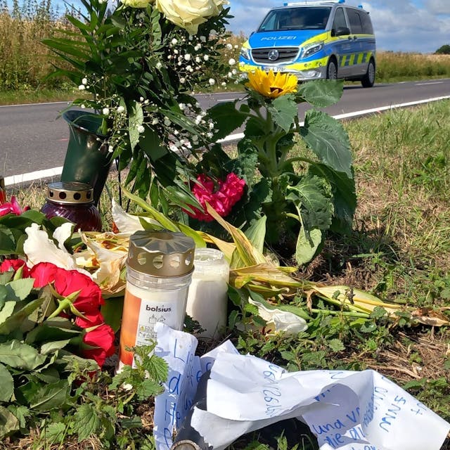 05. Juli 2023: Am Ort, an dem eine 17-Jährige auf einem E-Bike nach dem Frontalzusammenstoß mit einem Auto starb, zwischen Villip und Gimmersdorf, liegen Blumen und Kerzen sowie eine Nachricht von Freunden mit einem abgebrochenen Stück Lenker.