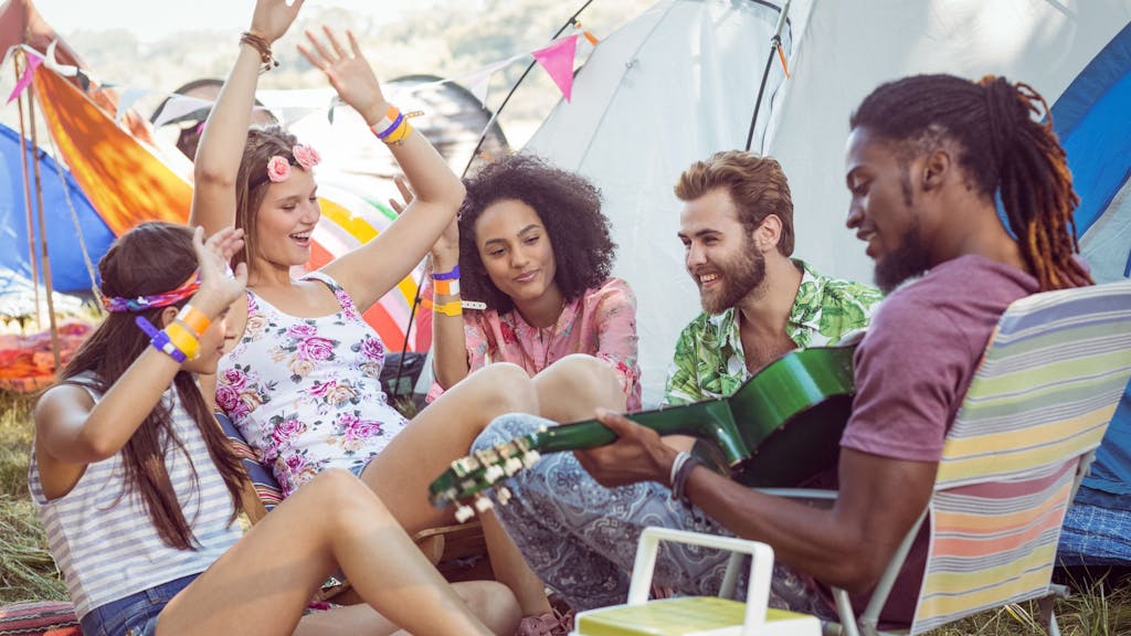 Hipsters having fun in their campsite at a music festival 