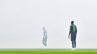 Nico Elvedi (l.) und Marcus Thuram stehen im Pyro-Nebel im Stadion des 1. FC Köln beim Derby am 2. April 2023.