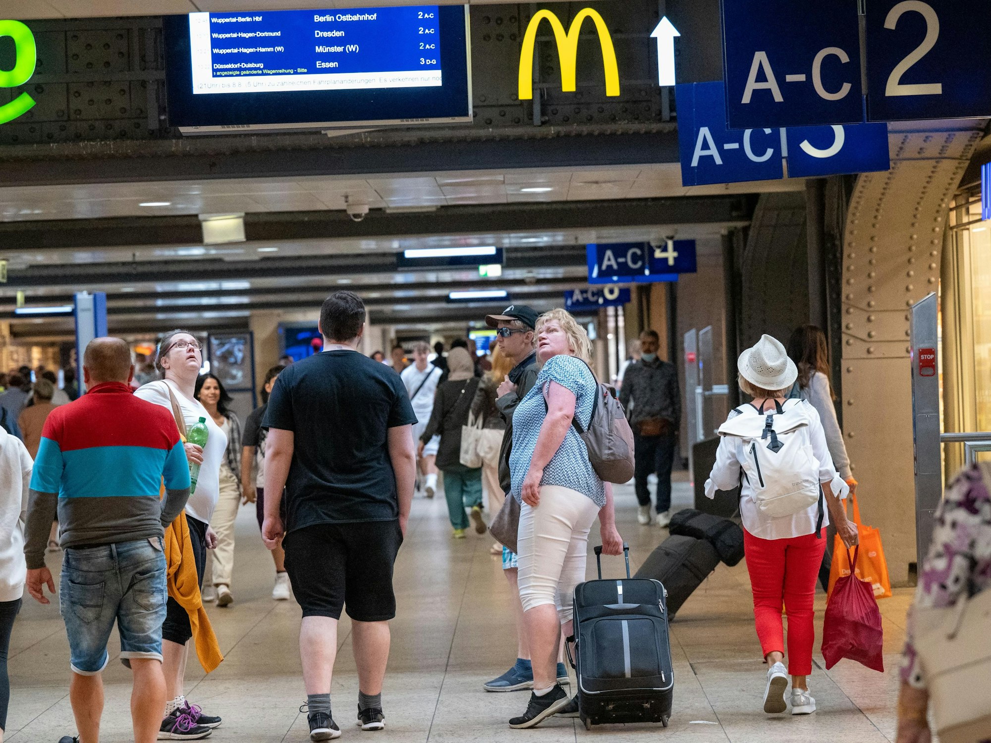 Reisende suchen nach Informationen auf den Anzeigetafeln im Kölner Hauptbahnhof.