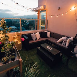 Ein Balkon mit Sofa, Lichterkette Gartenmöbeln.
