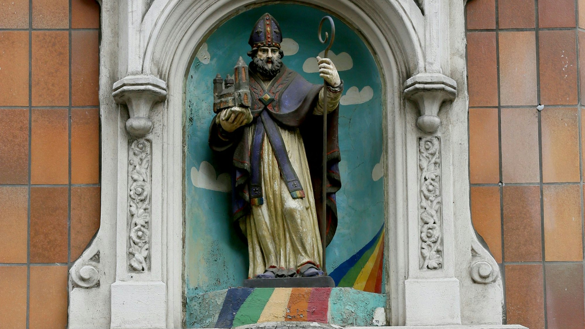 Eine Figur des Heiligen Severin an der Fassade eines Hauses.