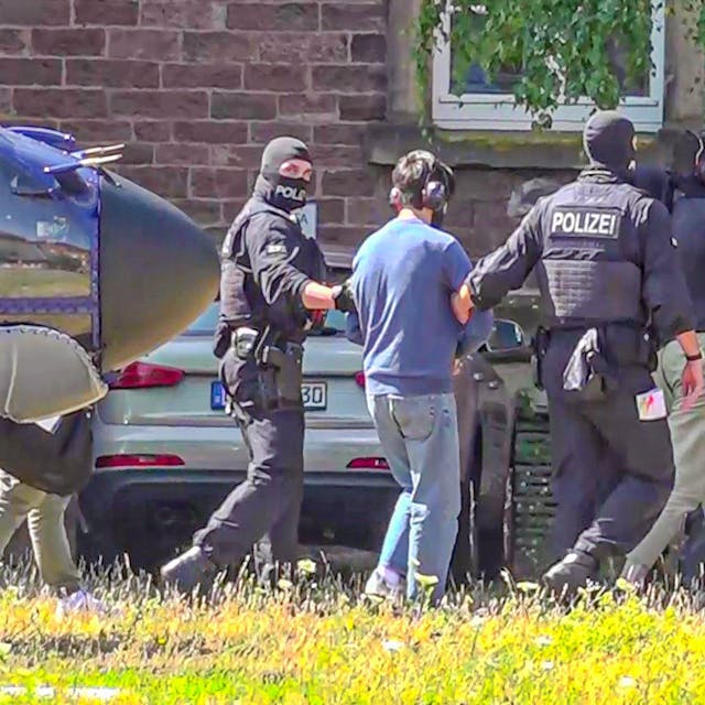 Zwei der Terrorverdächtigen werden von Polizisten zur Vorführung vor dem Haftrichter gebracht. Die Bundesanwaltschaft hat in Nordrhein-Westfalen eine mutmaßliche islamistische Terrorzelle aufgedeckt und sieben Verdächtige festnehmen lassen.
