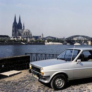 Ein silberner Ford Fiesta am Rhein mit dem Kölner Dom und der Hohenzollernbrücke im Hintergrund.