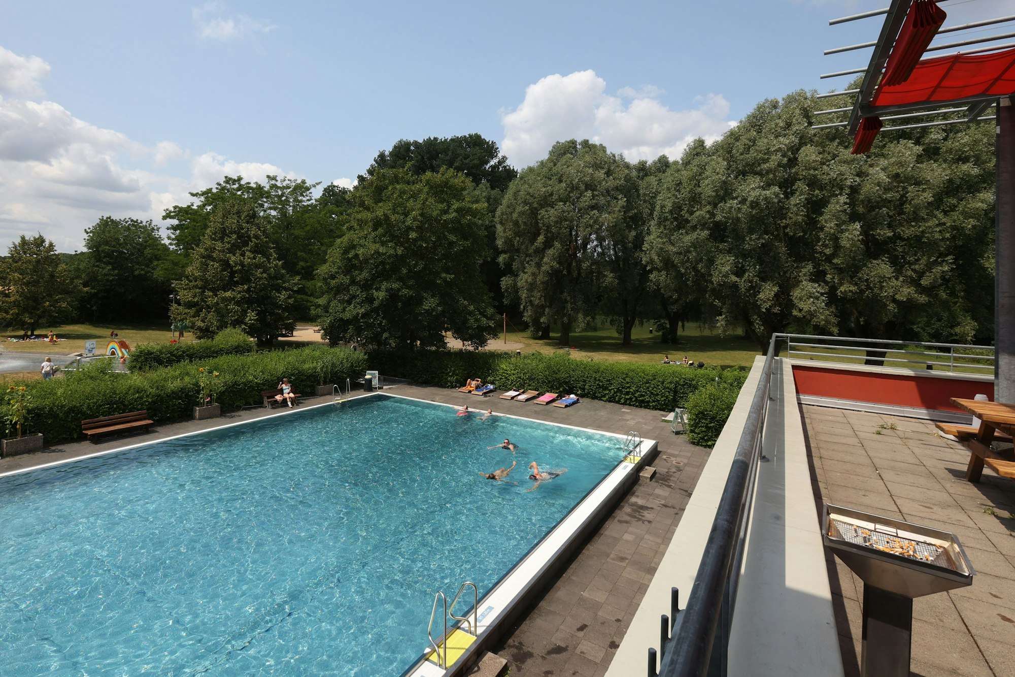 Das Bild zeigt den Blick von der Imbiss-Terrasse auf das große Schwimmbecken im Zündorfpark.