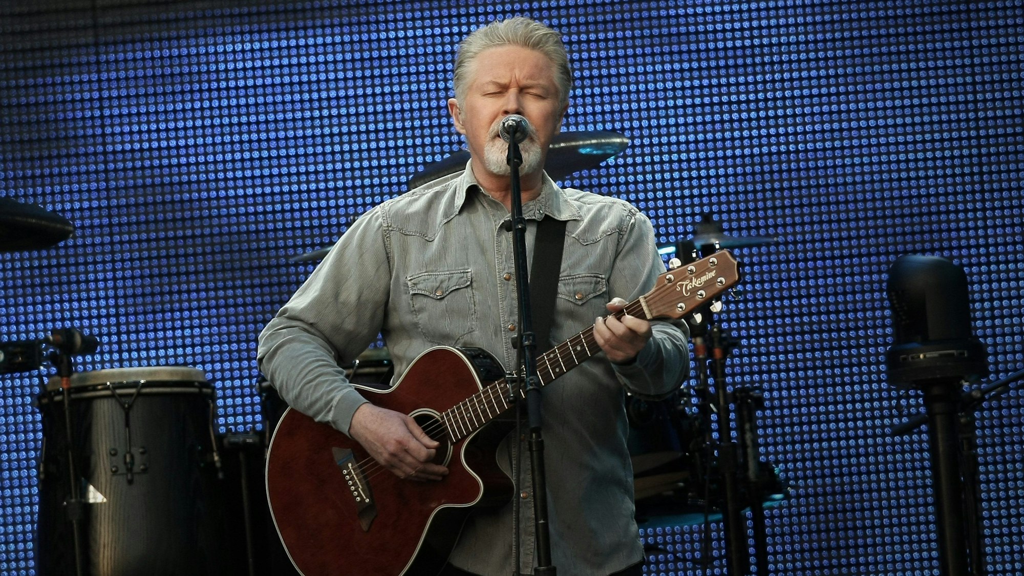Don Henley von den Eagles singt und spielt Gitarre.