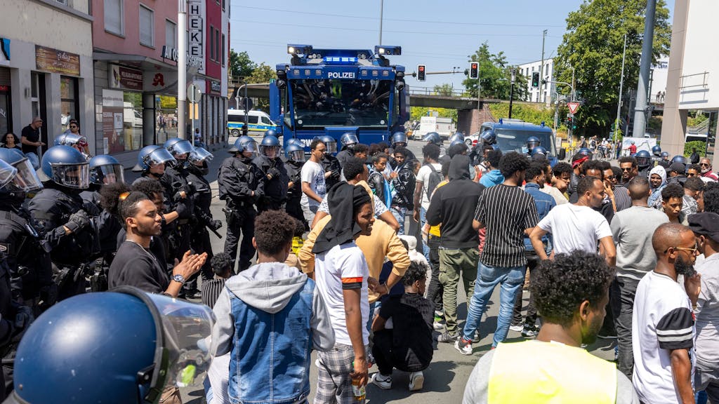 Polizisten haben am Rande des Eritrea-Festivals in Gießen eine Gruppe von Menschen umringt und im Hintergrund steht ein Wasserwerfer bereit.