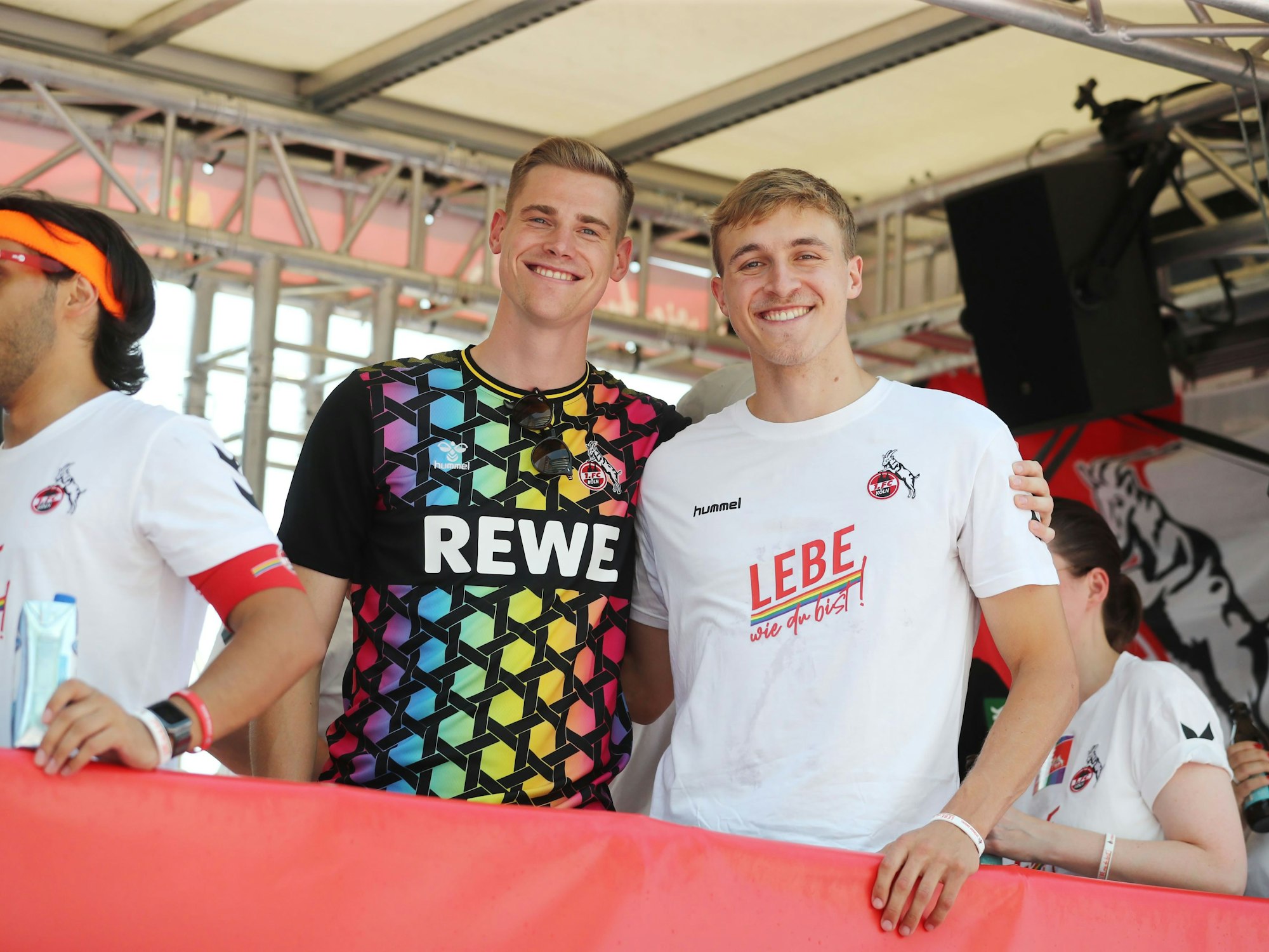 Steffen Tigges (Mitte) und Timo Hübers (re.) am 9. Juli auf dem CSD-Wagen des 1. FC Köln.

