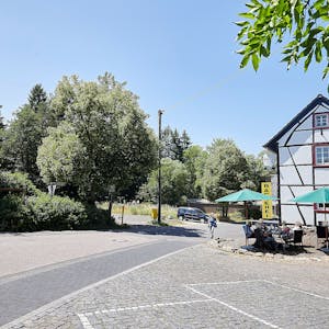 Auf dem Bild ist links das Café zur Römerquelle zu sehen, rechts der Parkplatz, auf dem ein Neubau entstehen soll.