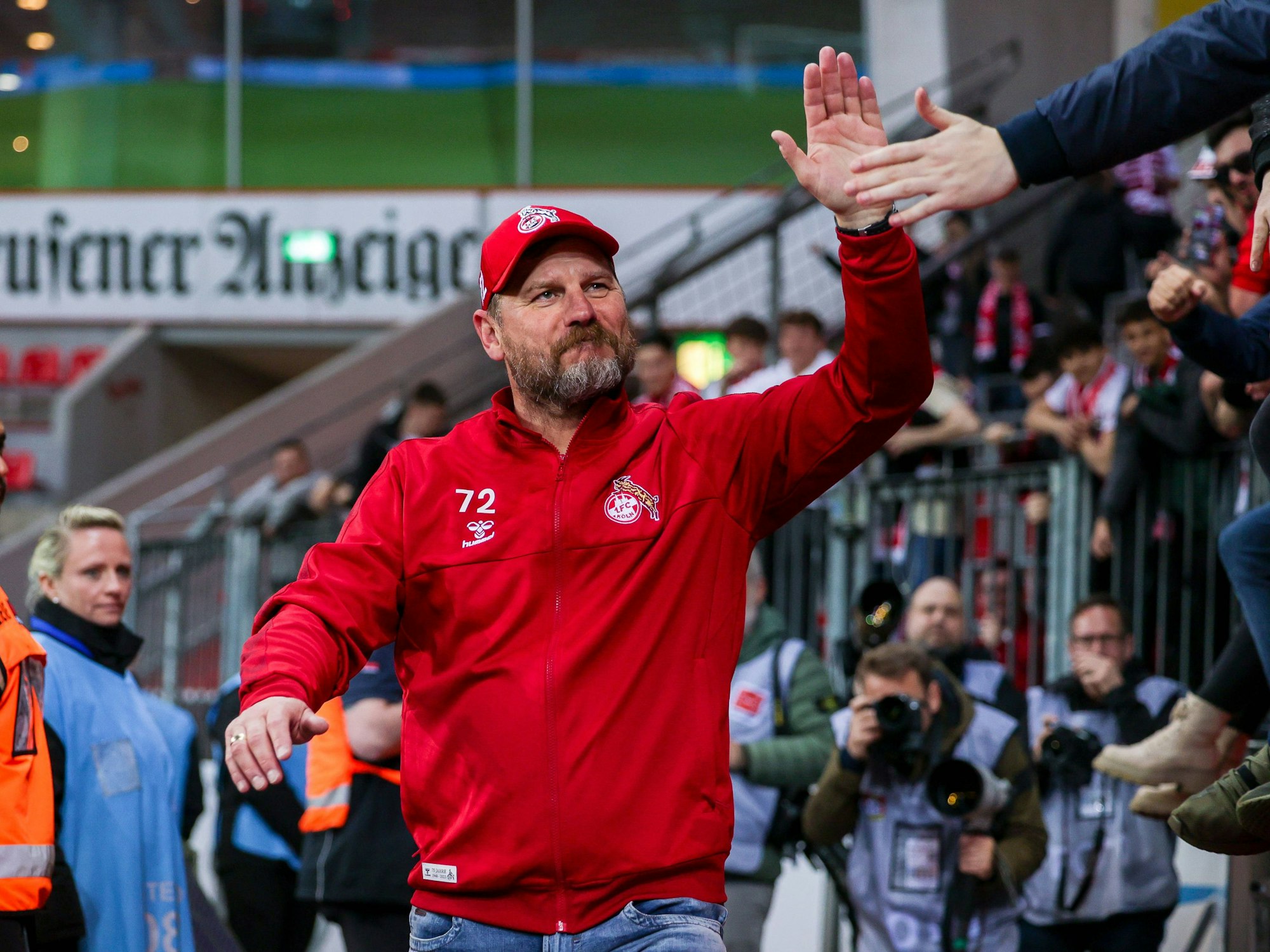 FC-Trainer Steffen Baumgart klatscht nach dem 2:1-Sieg gegen Bayer Leverkusen am 5. Mai 2023 mit einem Fan ab.