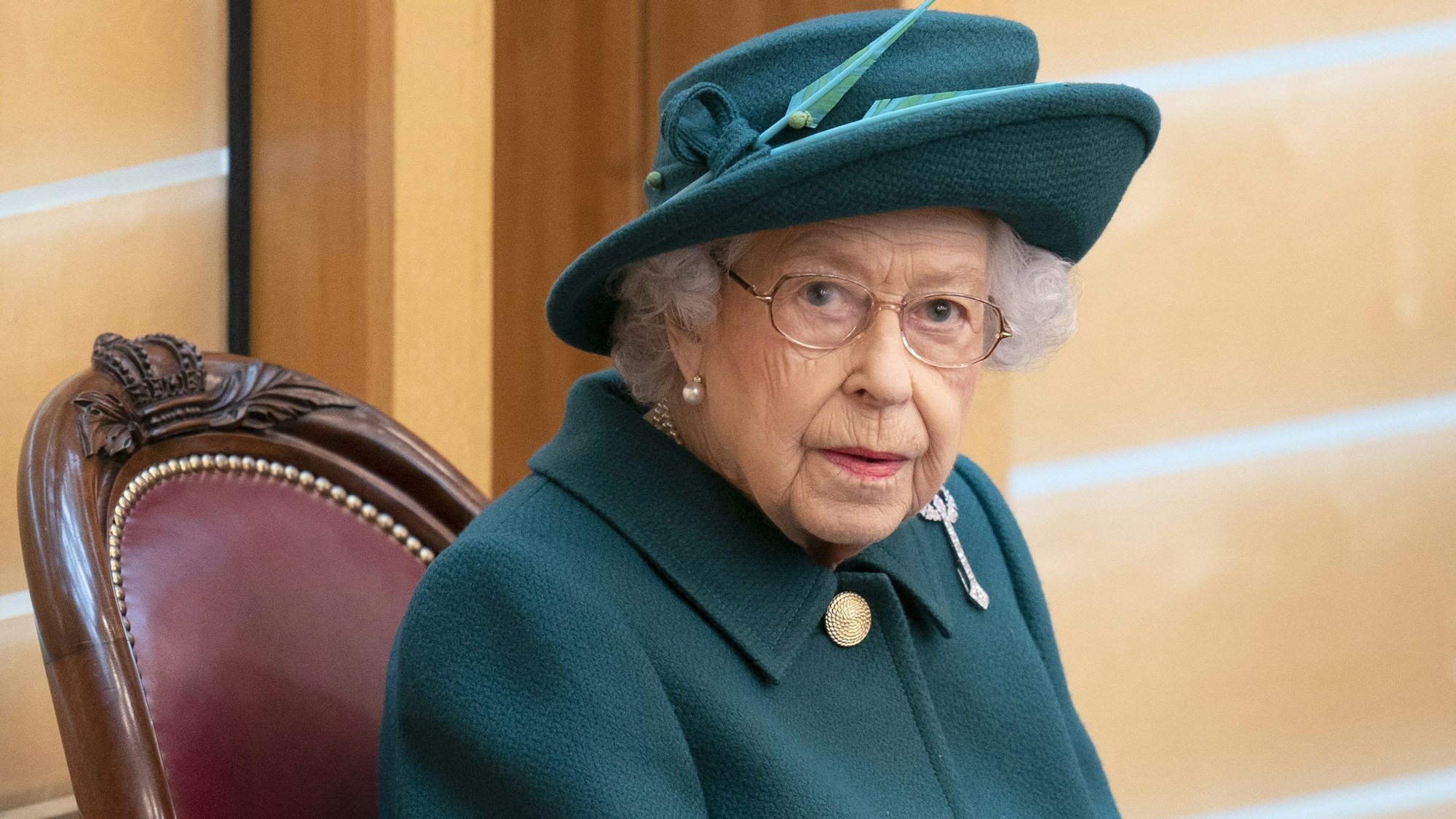 Königin Elizabeth II. sitzt auf einem Stuhl