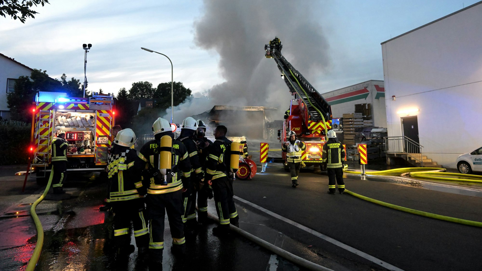 Feuerwehrleute bekämpfen mit eine Drehleiter einen Großbrand in Overath.