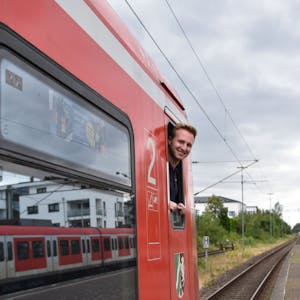 Ein Mann blickt aus dem Fenster eines Zuges.