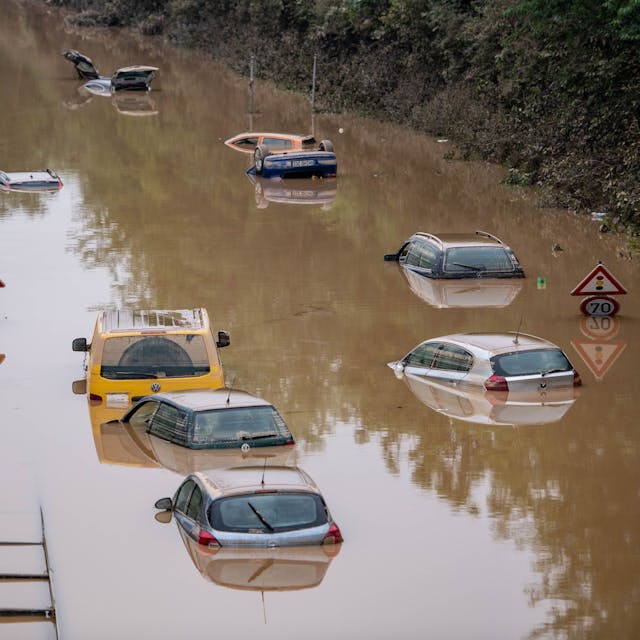 Autos stehen auf der überfluteten Bundesstraße 265 bei Erftstadt im Wasser.