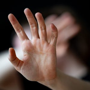 Eine Frau hält ihre Hände vor das Gesicht. (Illustration)