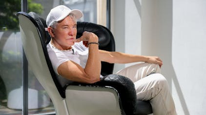 10.07.2023, Köln: Hollywood-Regisseur Baz Luhrmann sitzt in einem Drehsessel im Kölner Qvest-Hotel.

Er trägt eine weiße Baseball-Kappe, ein weißes T-Short und weiße Jeans.