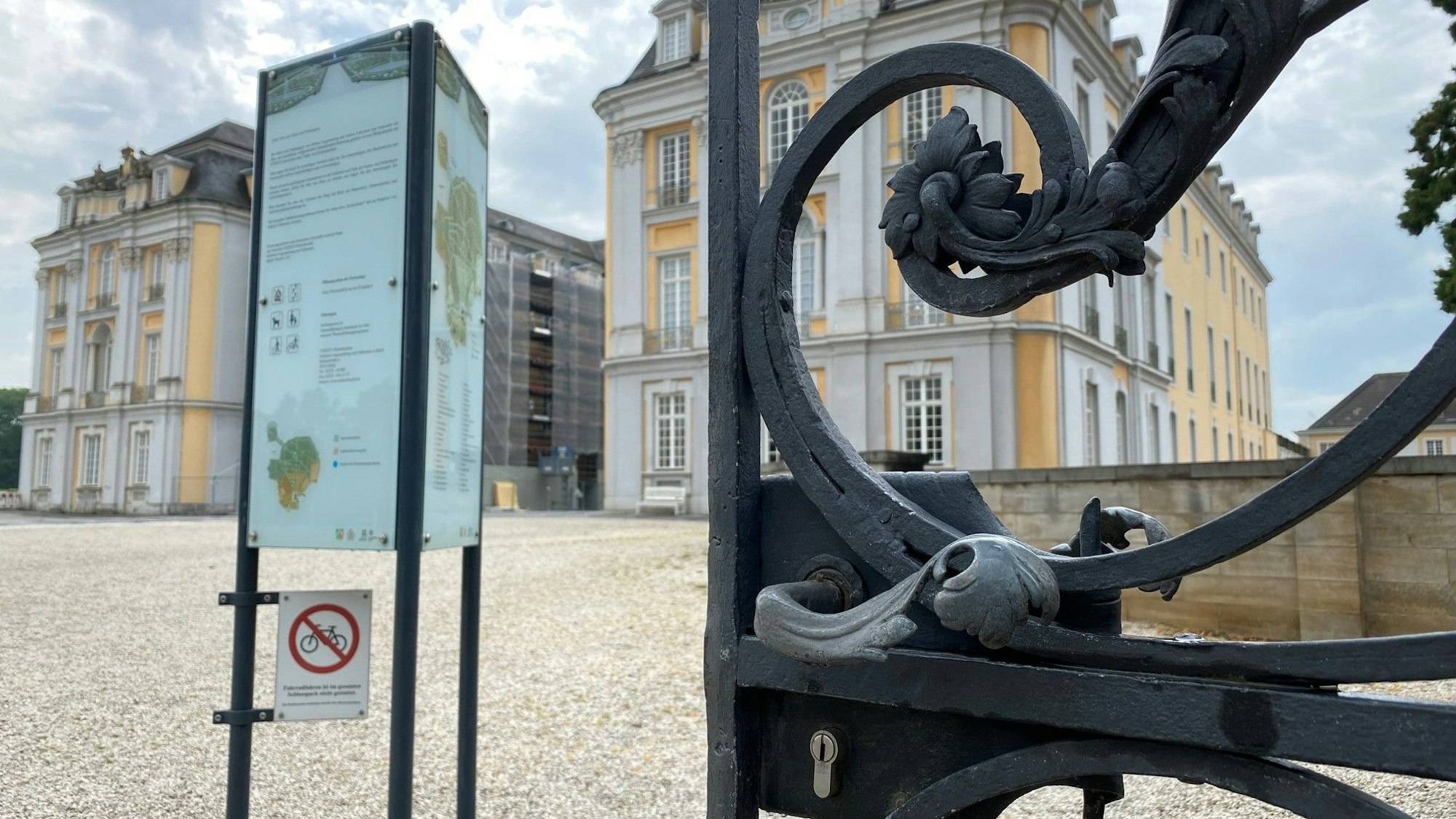 Das Bild zeigt das Brühler Schloss Augustusburg hinter einer geschmiedeten Pforte.
