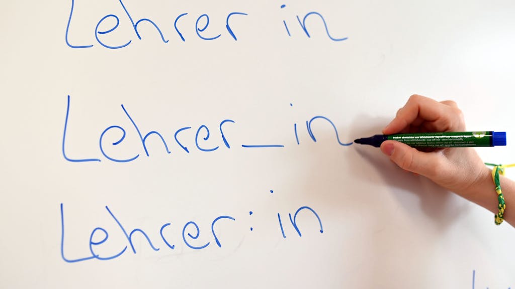 An einem Whiteboard steht das Wort „Lehrer“ in drei verschiedenen Gender-Schreibweisen.
