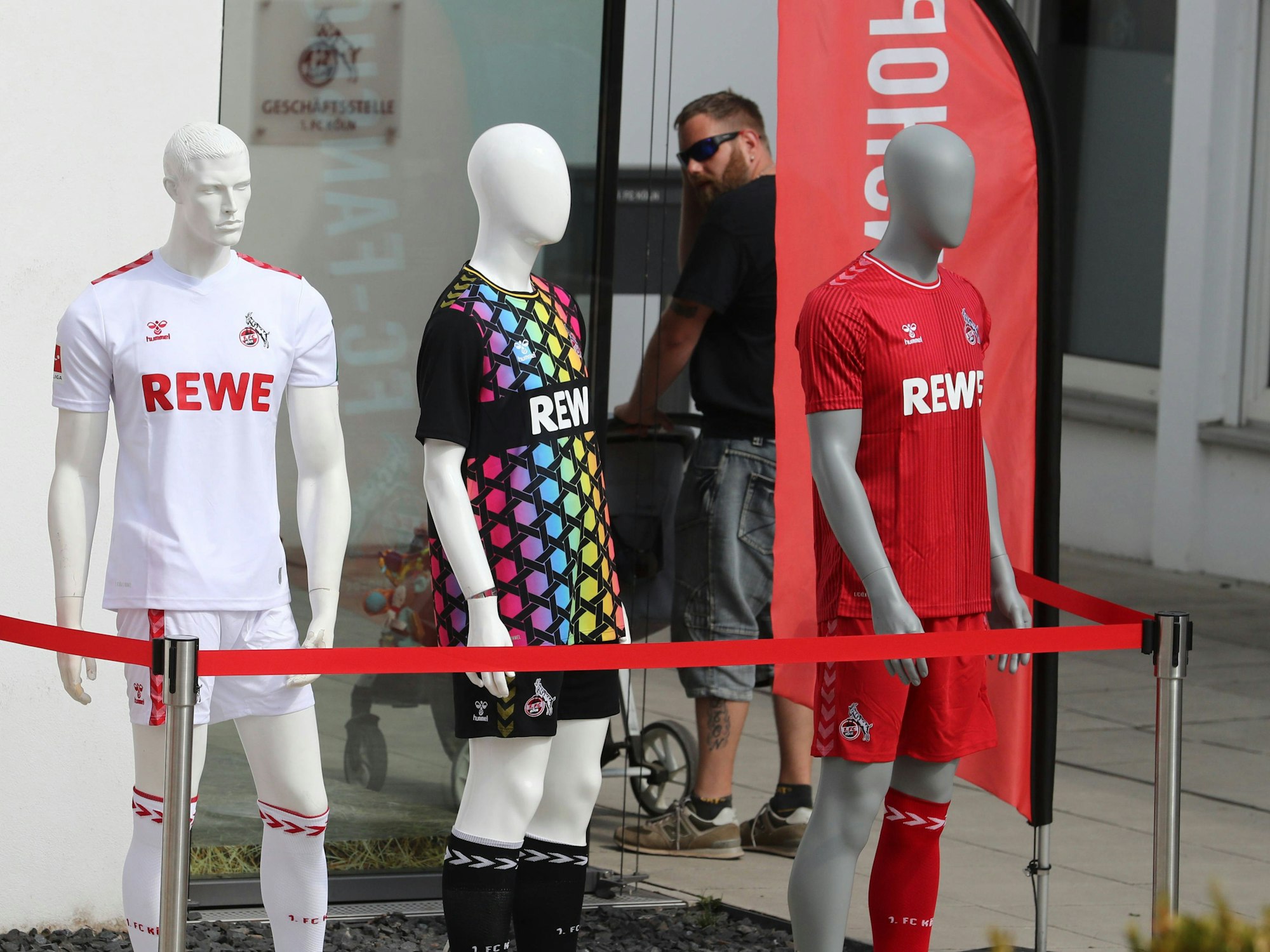 Die drei Trikots des 1. FC Köln vor einem Fanshop in Köln.