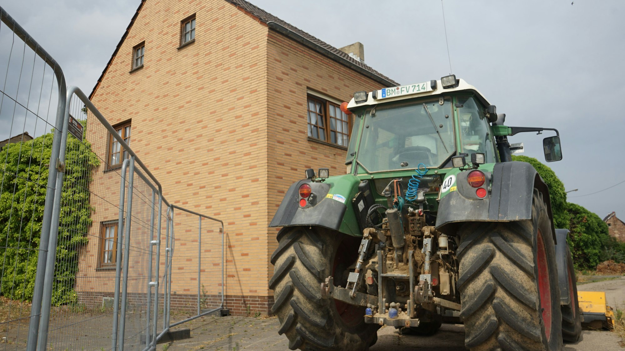 Der letzte Hof in Manheim, vor dem Gebäude steht ein Traktor.