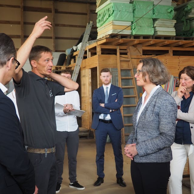 Das Bild zeigt NRW-Ministerin Ina Scharrenbach im Gespräch mit dem dem Bauunternehmer Bastian Boße.