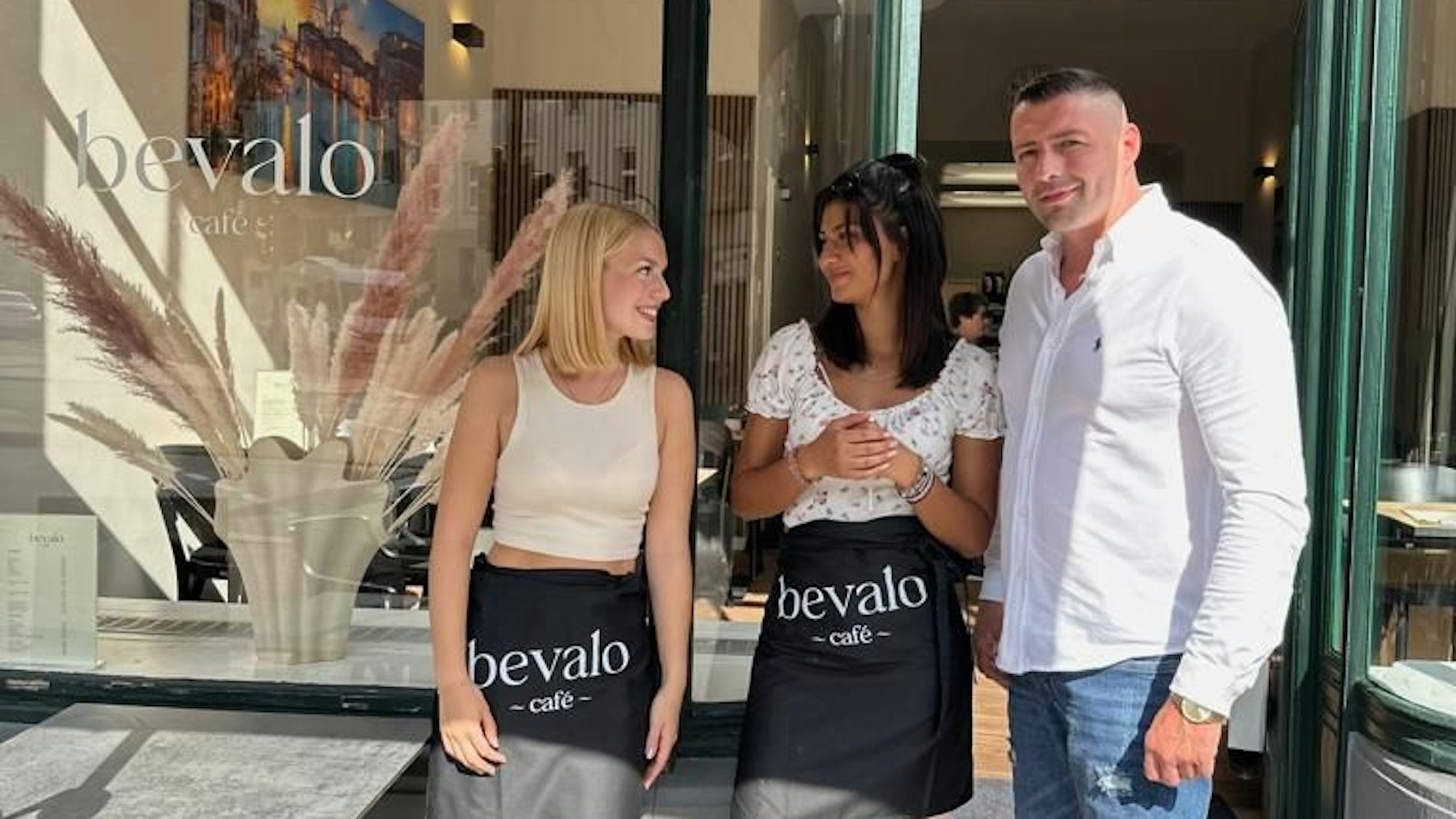 Besnik Miroci mit zwei Mitarbeiterinnen vor dem neuen Café in Nippes.
