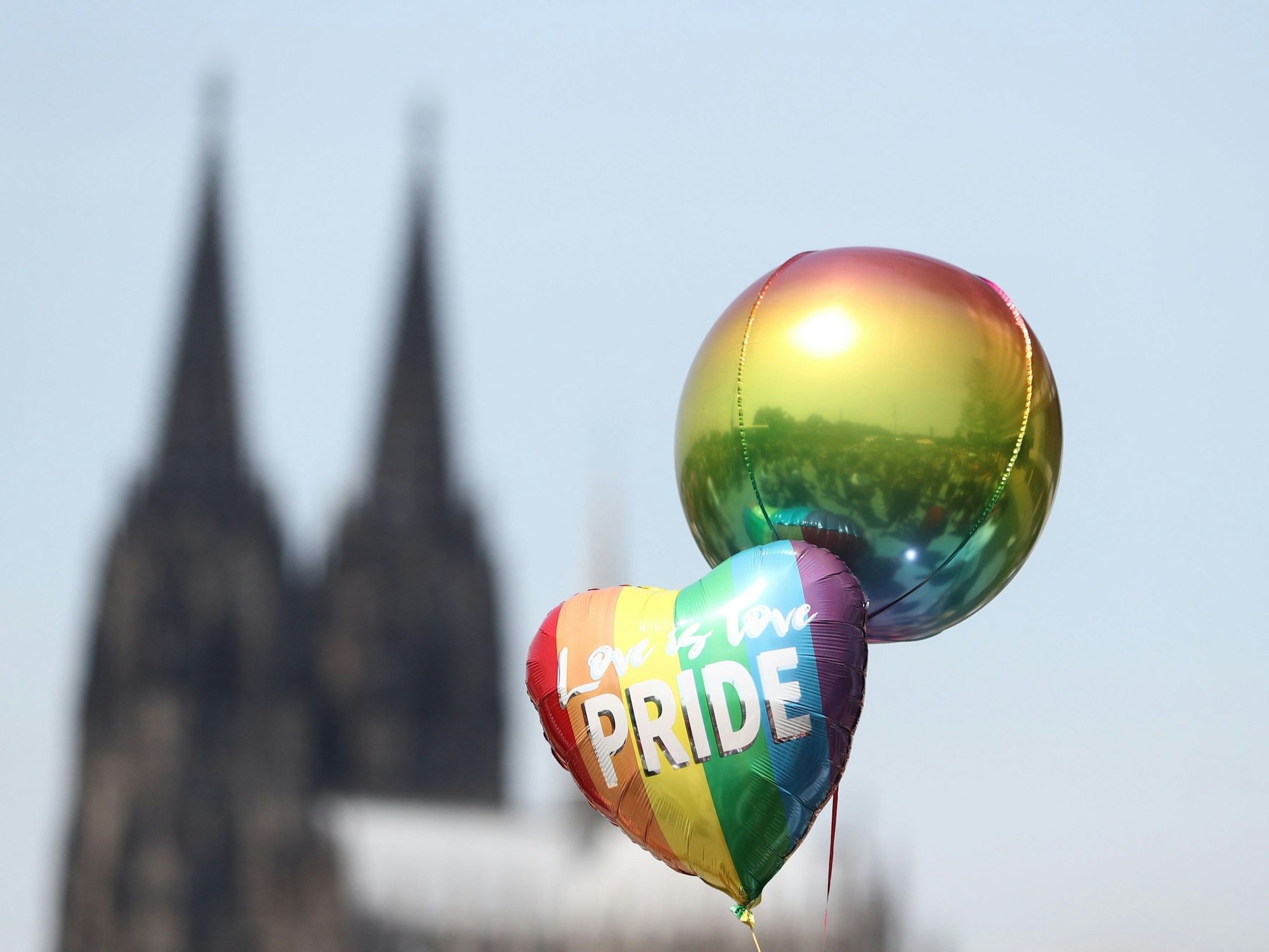 Ein Foto von zwei Regenbogen-Luftballons vor dem Kölner Dom während der CSD-Parade.