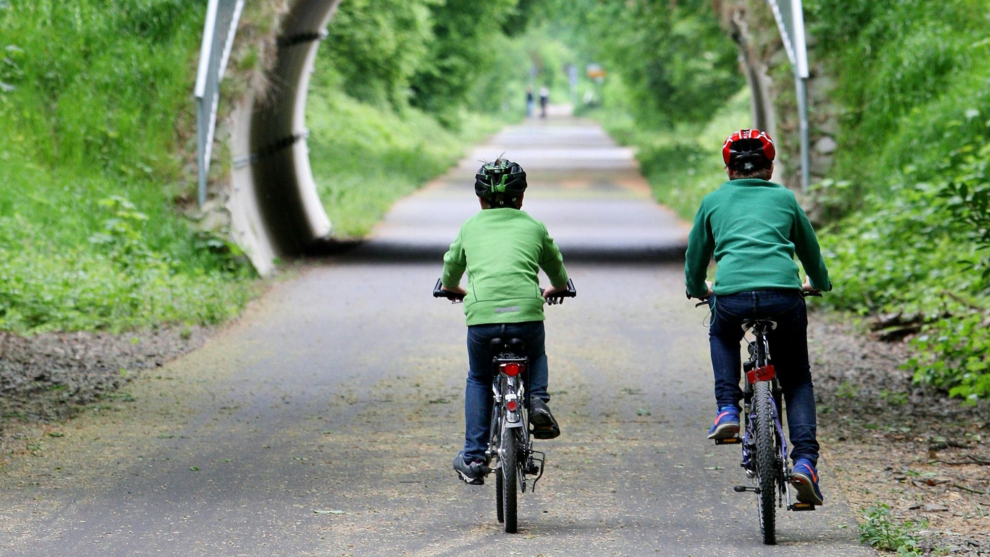 Zwei Kinder fahren Fahrrad.