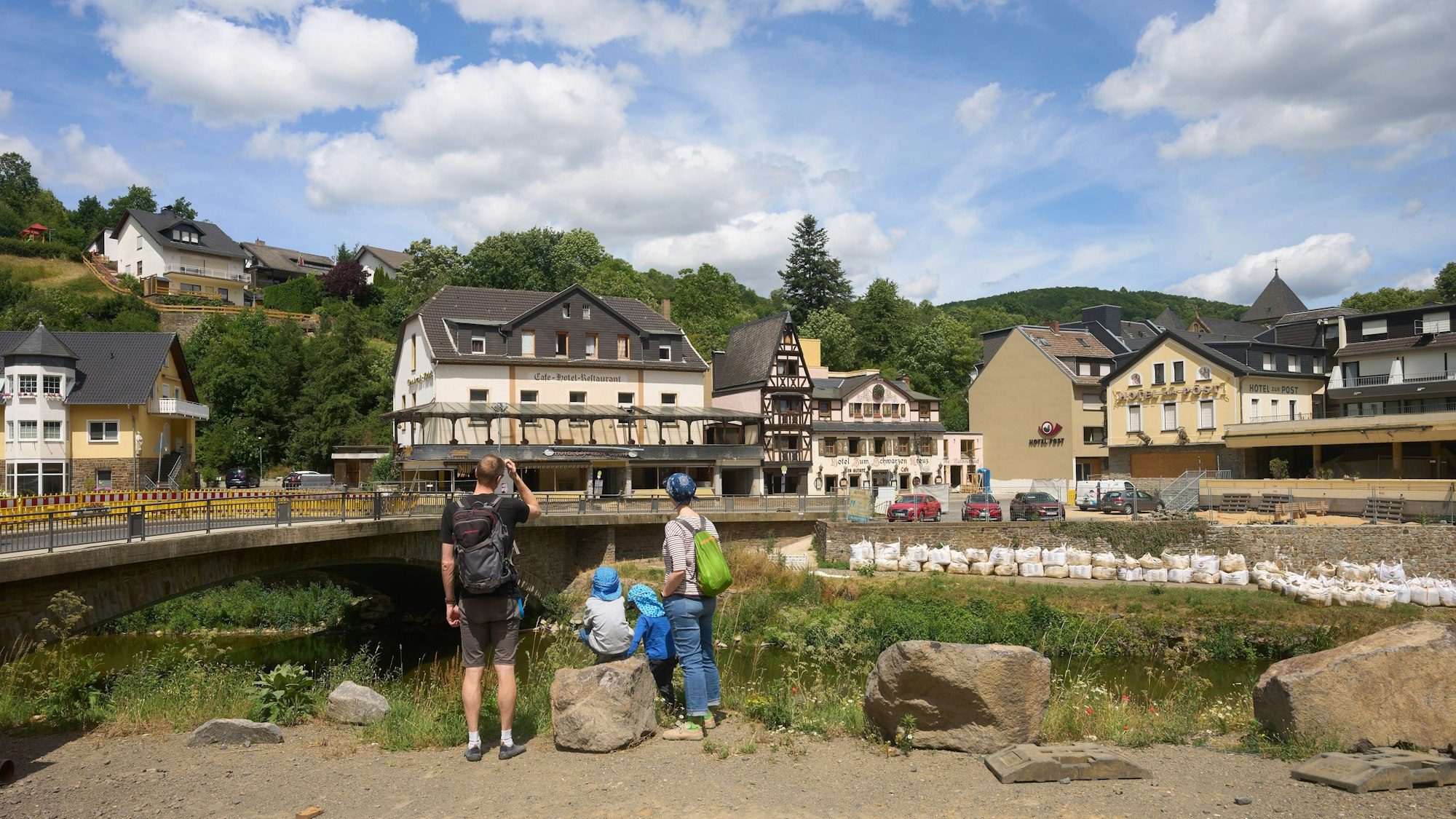 PRODUKTION - 06.07.2023, Rheinland-Pfalz, Altenahr: Eine Touristenfamilie steht an einer Brücke über den Fluss Ahr. Zwei Jahre nach der Flutkatastrophe an der Ahr wird bei zahlreichen Gedenkveranstaltungen an die Opfer und Betroffenen erinnert. (zu dpa: «Gedenken am zweiten Jahrestag der tödlichen Flutkatastrophe im Ahrtal») Foto: Thomas Frey/dpa +++ dpa-Bildfunk +++