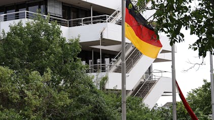 Eine Deutschlandflagge weht an einem Fahnenmast, im Hintergrund ist das Euskirchener Kreishaus zu sehen.
