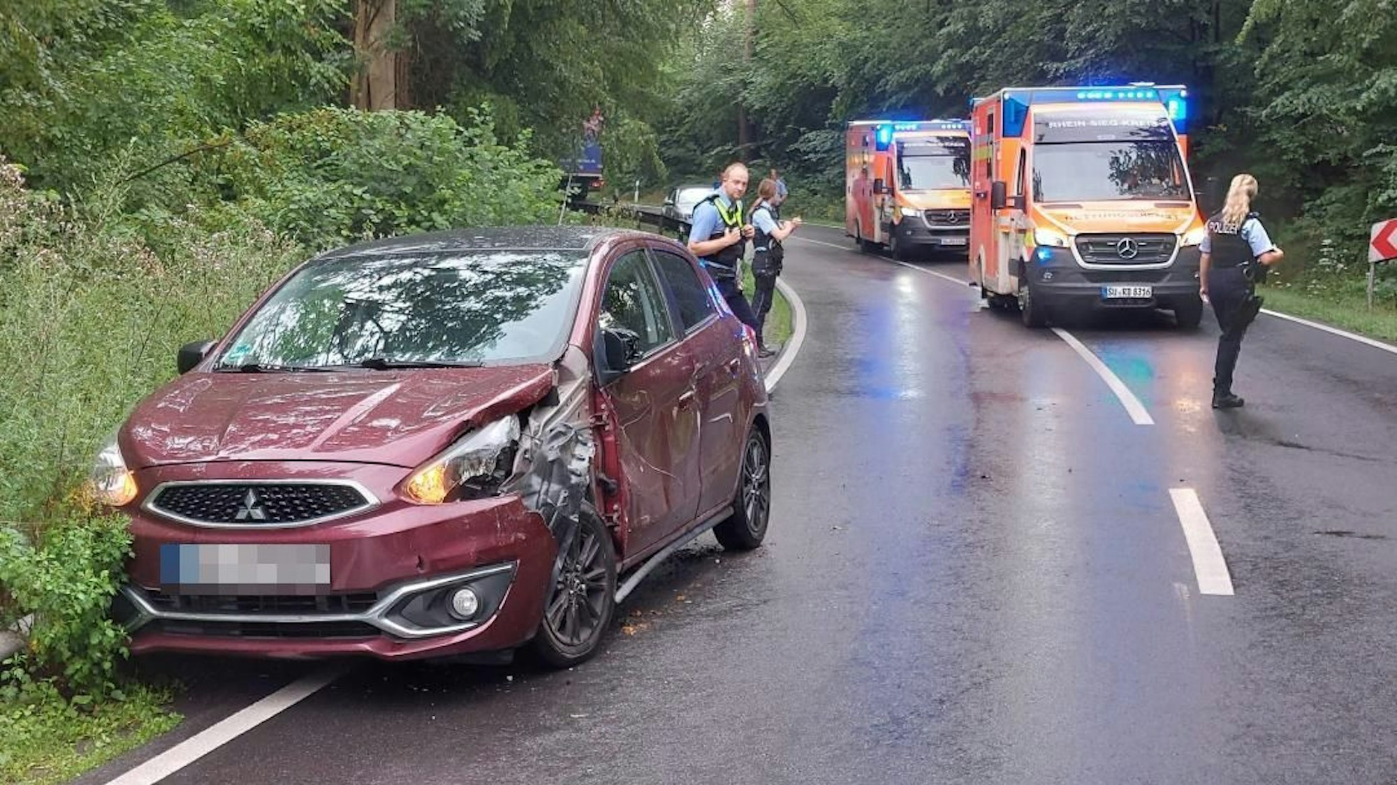 Ein roter Kleinwagen wurde bei einem Unfall an der Seite beschädigt.