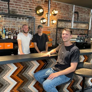 Drei junge Männer an einer Bar