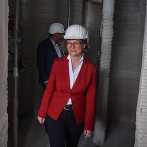 Ina Scharrenbach (CDU) geht durch die Baustelle von Europas erstem öffentlichen Gebäudes aus dem 3D-Drucker.