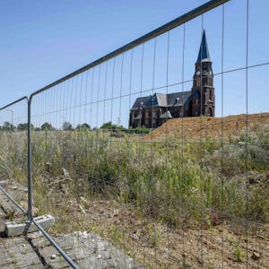 Auf dem Foto ist hinter einem Bauzaun die Kirche von Manheim-alt zu sehen.