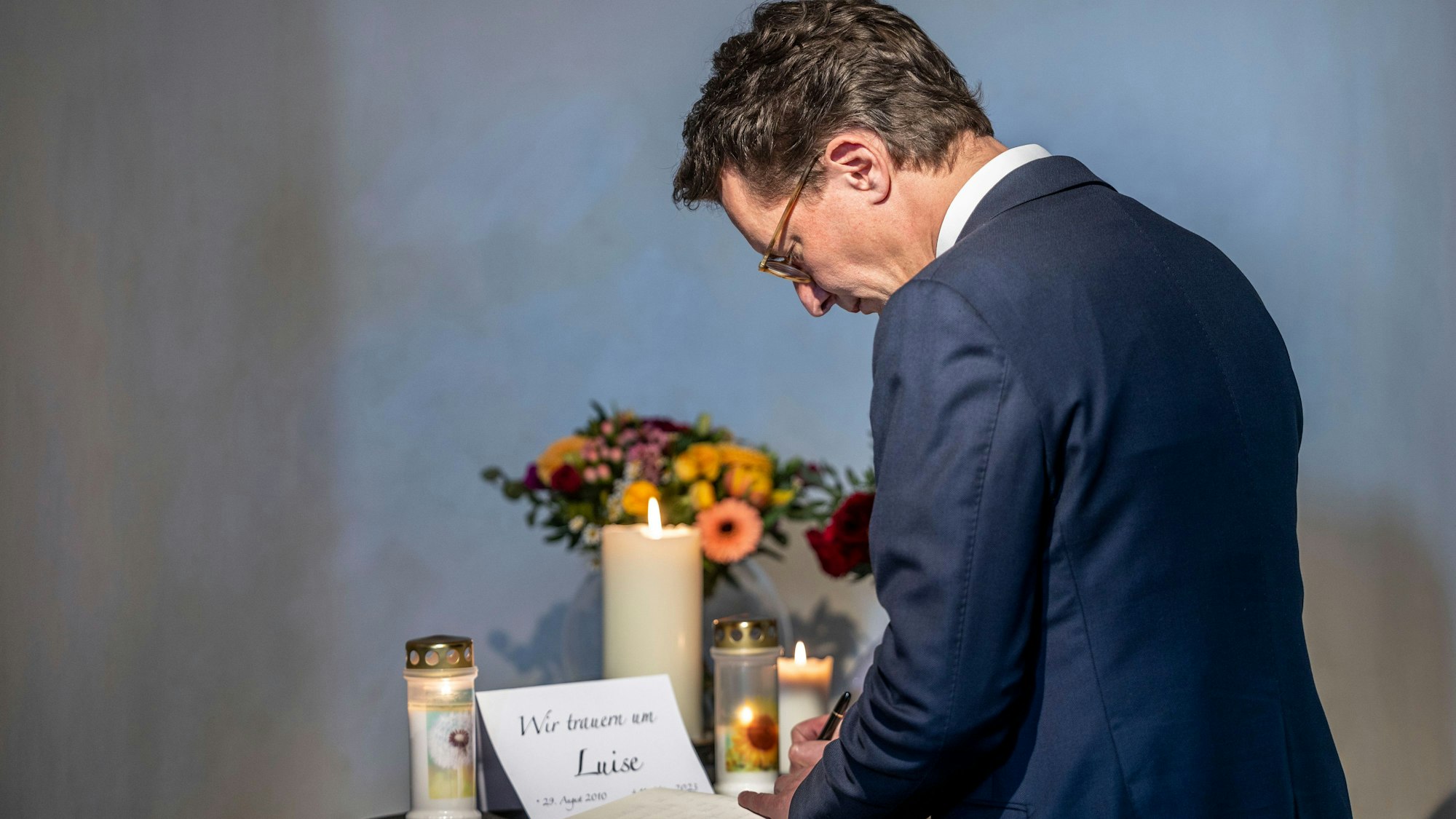 Hendrik Wüst (CDU), Ministerpräsident von Nordrhein-Westfalen, trägt sich bei einer Trauerfeier für die getötete Luise aus Freudenberg in das Kondolenzbuch ein.