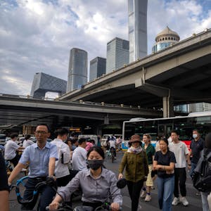 Pendler überqueren am 13. Juni 2023 während der abendlichen Rushhour eine Kreuzung im zentralen Geschäftsviertel von Peking.