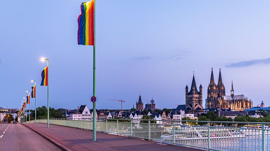 Regenbogenflagge mit Kölner Dom im Hintergrund