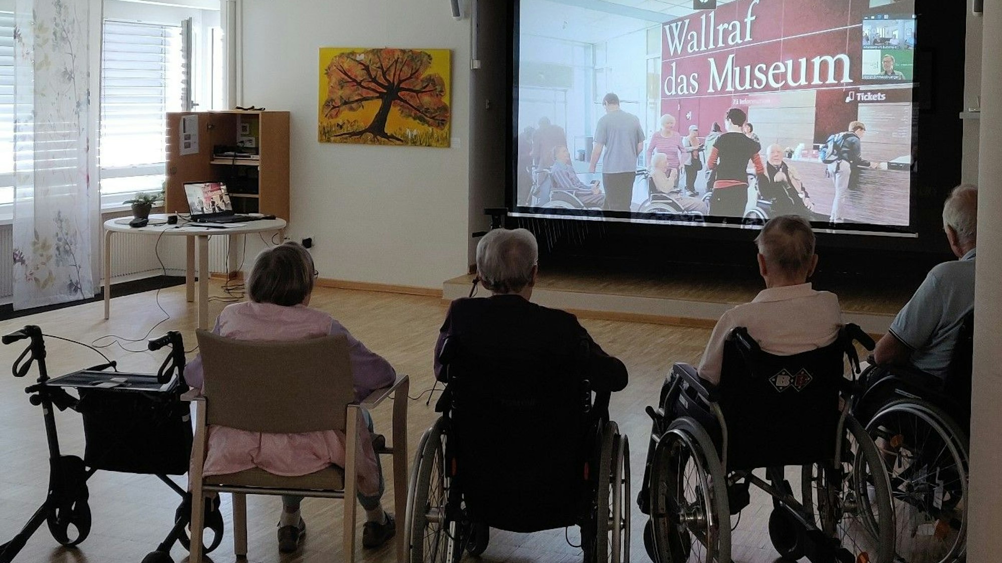 Senioren sitzen bei der digitalen Museumsführung im Burscheider Altenheim Luchtenberg-Richartz-Haus vor der Leinwand.