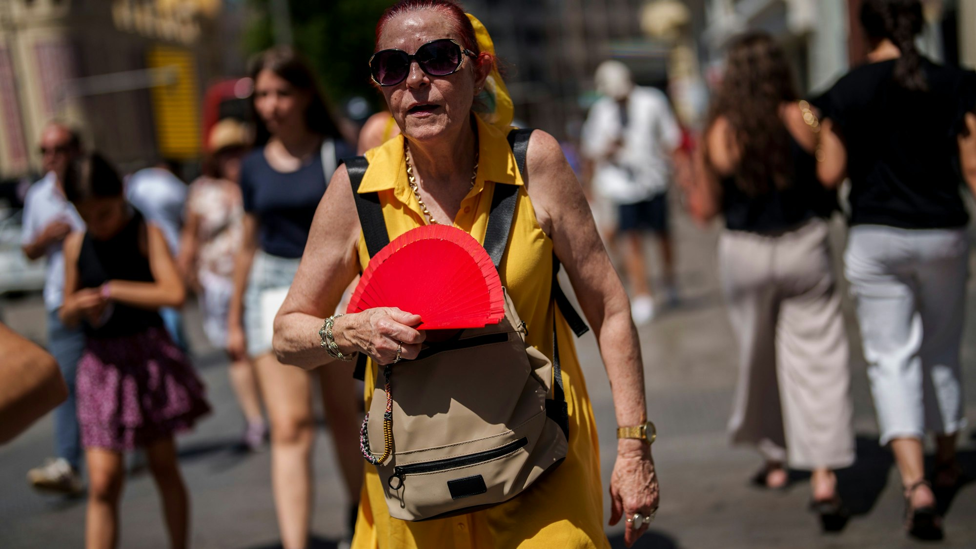 Hier wedelt sich eine Frau in Madrid Mitte Juli Luft zu.